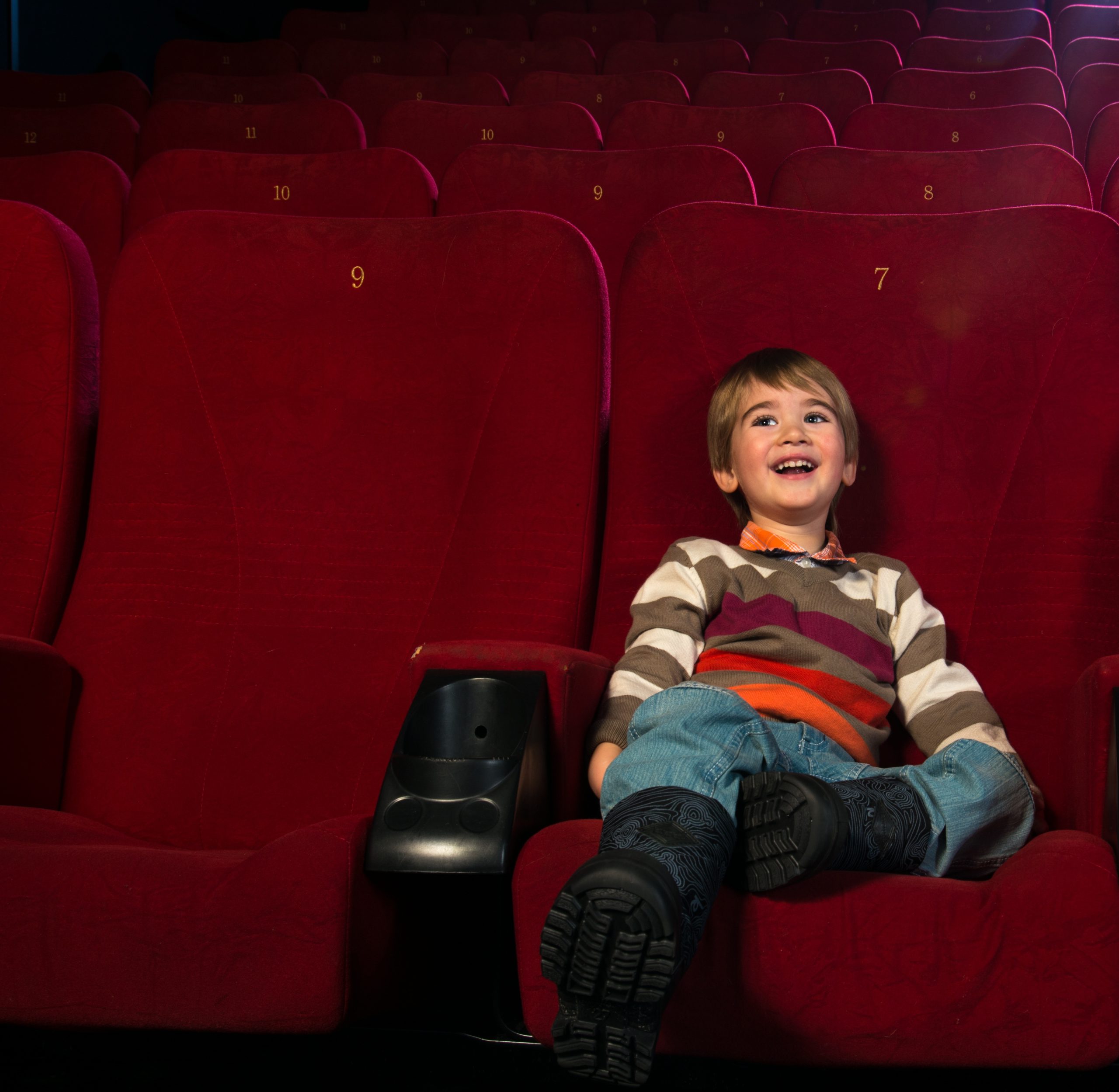 Smiling little boy watching movie in a cinema